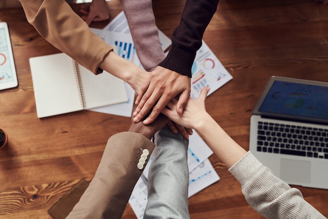 people piling hands in the center of a table